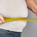 Obese man measures his waist